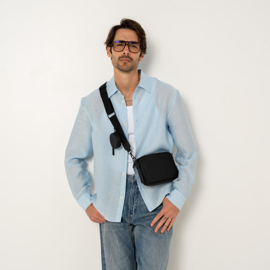 Sacoche vegan joomi noir gros plan porté par un homme de face